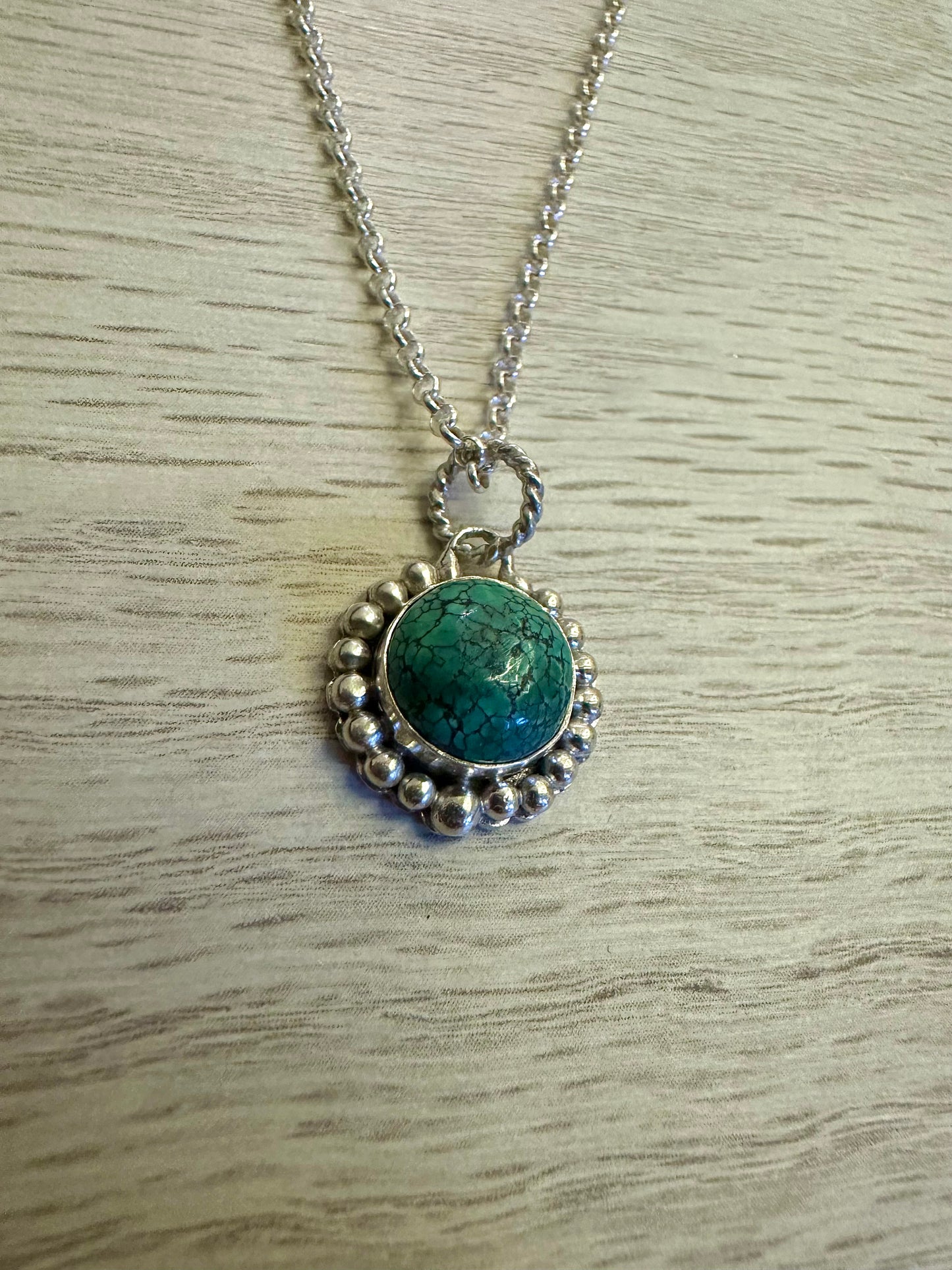 Handcrafted Turquoise pendant bezel set with silver granules surrounding the center stone. This Necklace is completely handcrafted and it's a perfect gift for a December birthstone Necklace.