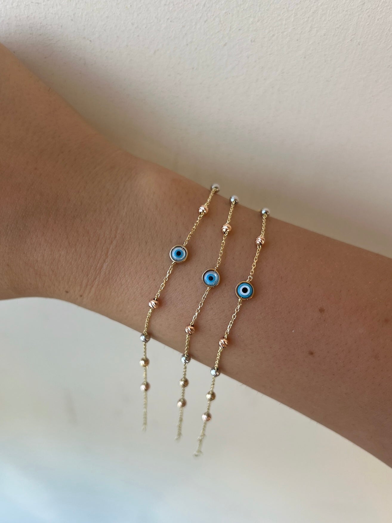 Evil Eye Bracelet featuring an 18 karat chain bracelet with Ojo Turco charm at its center and faceted gold beads adorning the chain | Ella Creations Jewelry