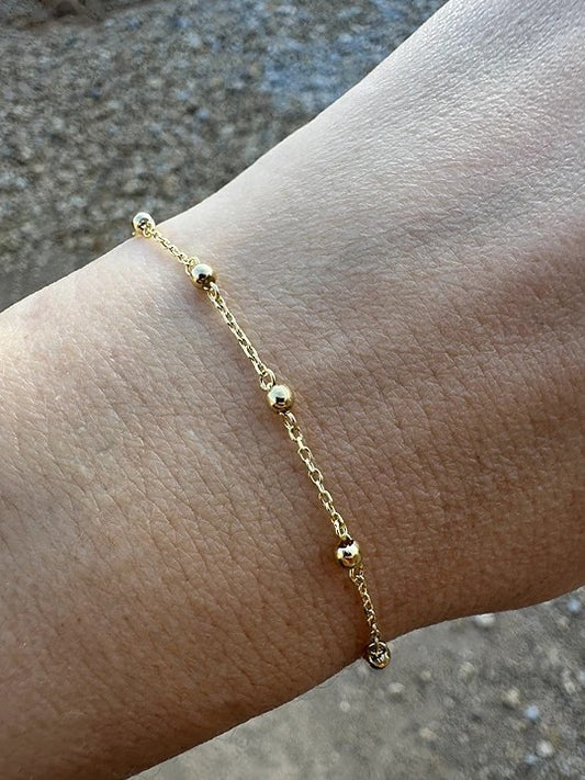 Gold Ball Bracelet featuring gold beads strung seamlessly on a delicate chain.
Perfect for a minimalistic stand alone look or for stacking with other bracelets | Ella Creations Jewelry