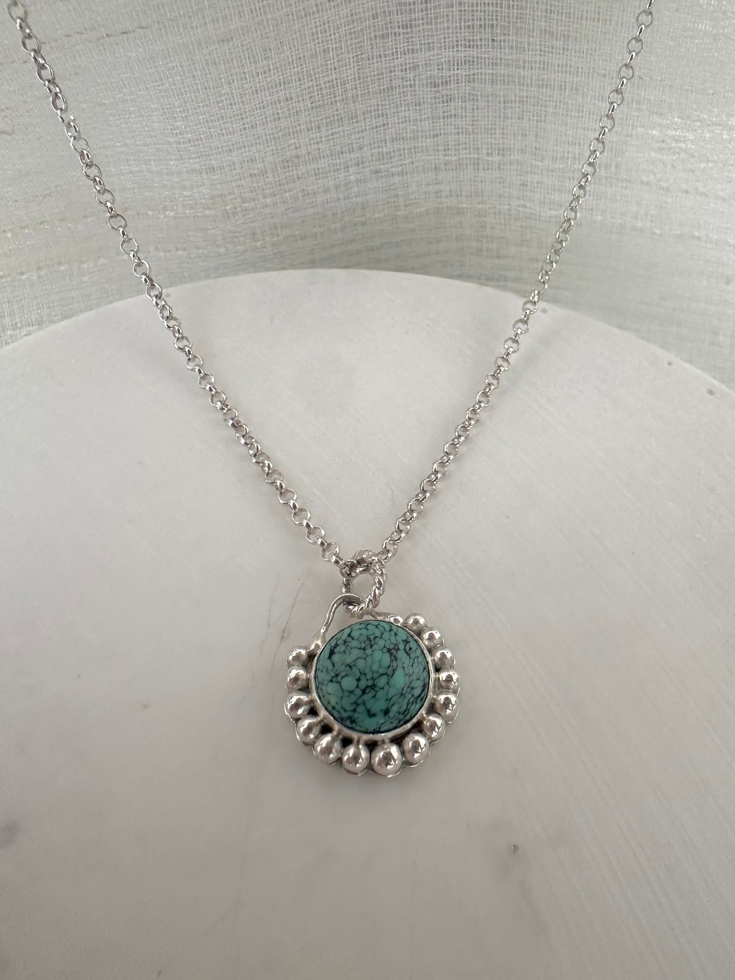 Handcrafted Turquoise pendant bezel set with silver granules surrounding the center stone. This Necklace is completely handcrafted and it's a perfect gift for a December birthstone Necklace.