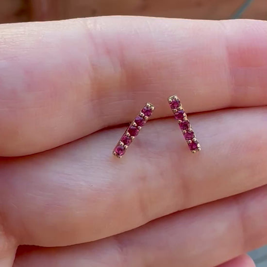 Beautiful and sleek Bar stud earrings adorned with 1.7mm round natural Ruby gemstones. Handcrafted in 18 karat Gold, these Ruby Stud Earrings have a linear design that makes them comfortable for everyday wear. Sold as pair.