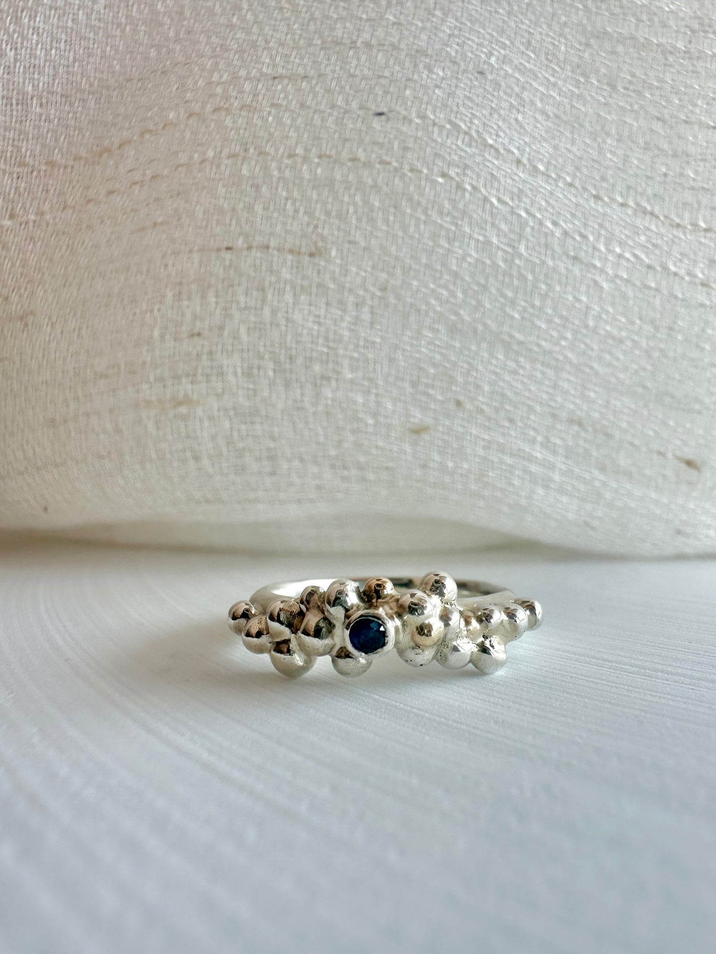 Recycled Sterling Silver ring handcrafted from a D shape wire, with the addition of many silver and gold granules soldered together to give a unique organic look, at the center I've added a tiny blue sapphire bezel set. Ring available in size 6 | Ella Creations Jewelry