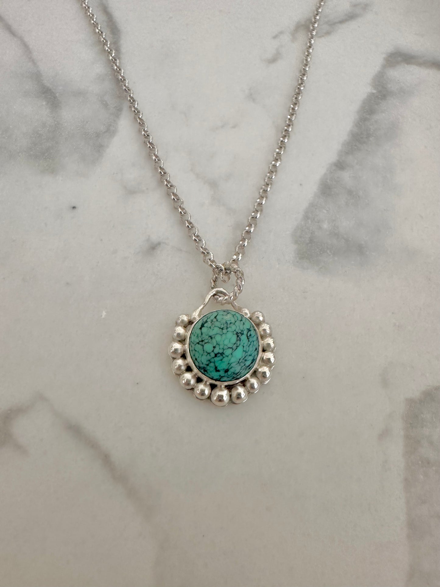 Handcrafted Turquoise pendant bezel set with silver granules surrounding the center stone. This Necklace is completely handcrafted and it's a perfect gift for a December birthstone Necklace.