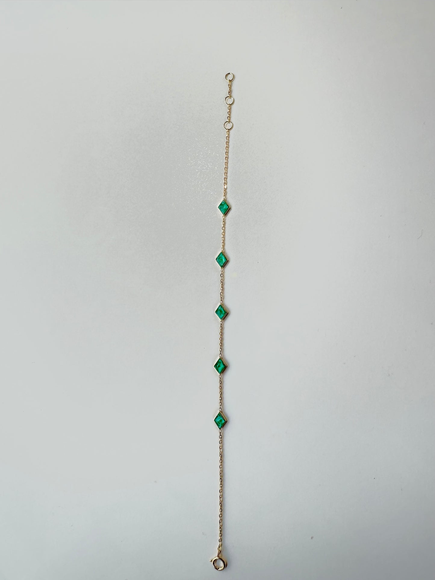 Handcrafted Rhombus Chain Bracelet, perfect for as an everyday bracelet and stacking. The dainty chain is adorned with 5 exquisite Rhombus charms, each featuring a hand-applied green malachite enamel finish. The bracelet is thoughtfully designed with an adjustable length, for a comfortable wear.