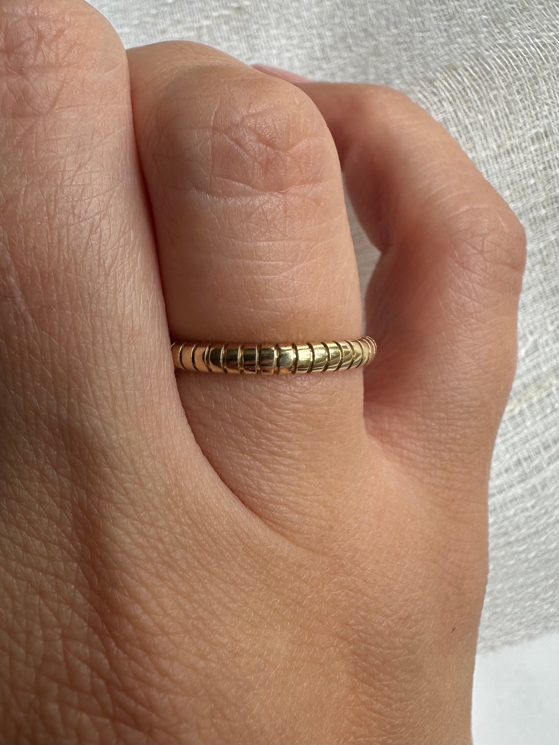 Elegant textured Ring, hand-crafted in 18 karat gold, and featuring a unique ribbed texture which adds a touch of elegance to this contemporary modernist ring. The band has a thickness of 2.5mm with an internal shank thickness of 1.5mm, making it ideal for a ring stack or as a thin wedding band. I offer customization on this band, you can chose to have it in Yellow, Rose or White gold.